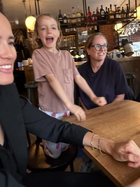 This lively photo captures three people enjoying a moment together inside a restaurant on Staalstraat, Centrum, Amsterdam
